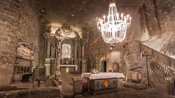 An underground stone chapel with an illuminated chandelier