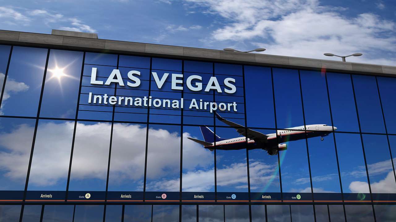 Blue-tinged airport terminal windows and white sign "Las Vegas International Airport"