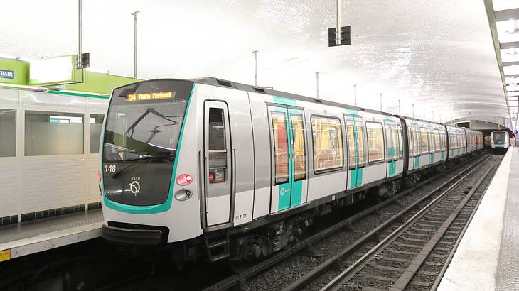 An underground train at a brightly-lit station platform