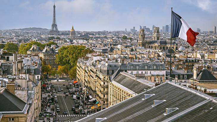 Skyline view of a city full of old buildings, with a flag in the foreground