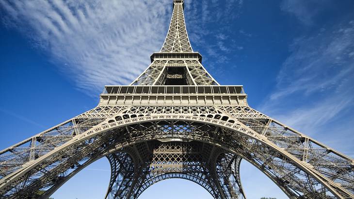 The metallic inside of a tall tower with ladders from below