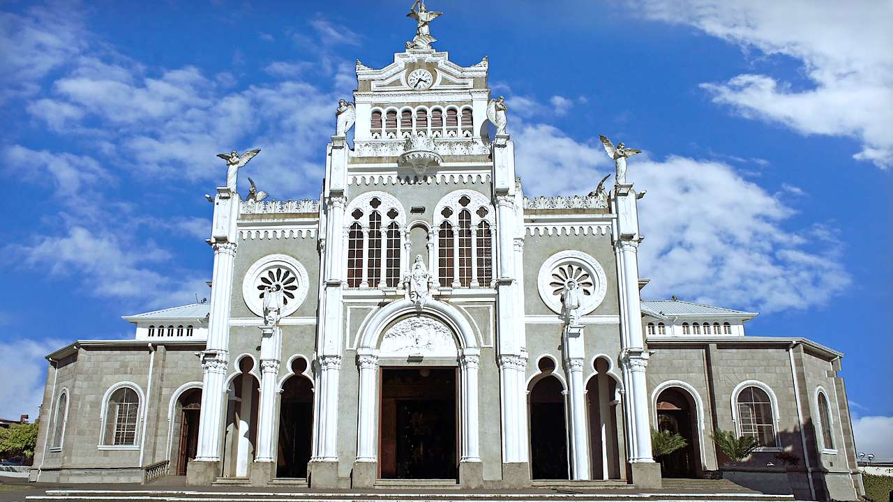 Front view of a white and gray basilica on a sunny day