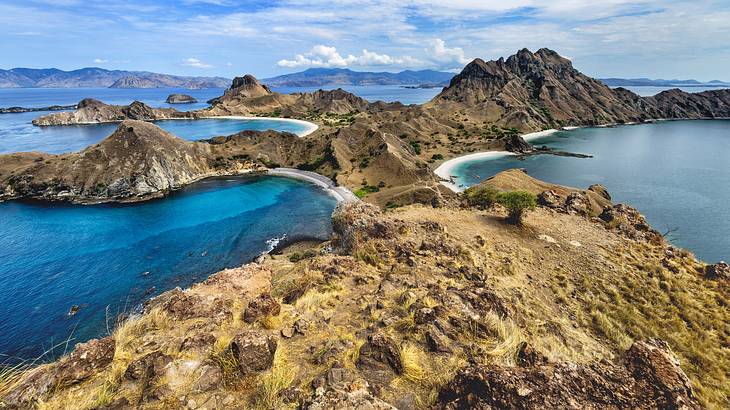 A dry, barren and rocky mountainous island surrounded by clear blue water