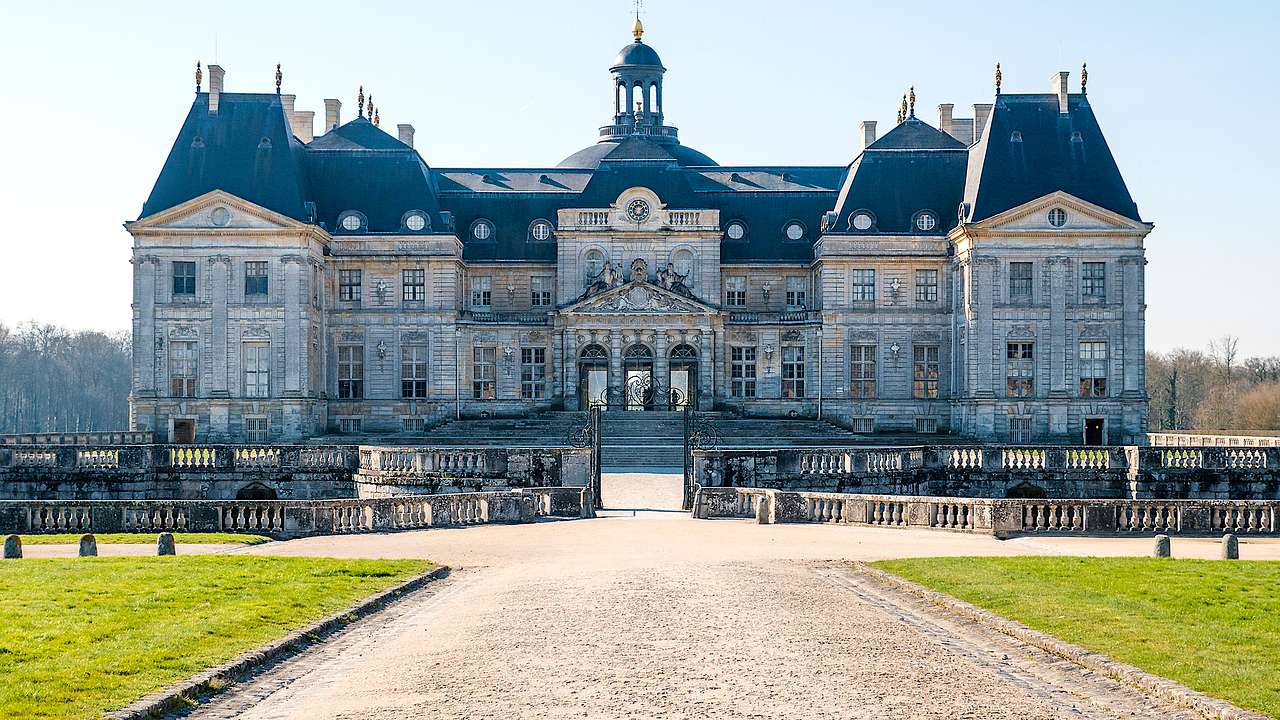 Grand exterior of Château de Vaux-le-Vicomte behind green grass on a nice day