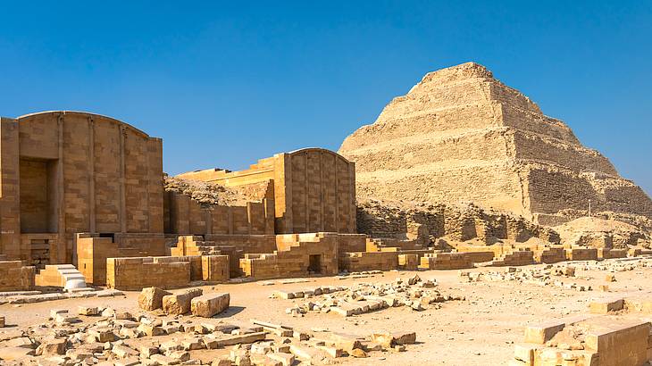 View of a pyramid and ancient ruins against a blue sky