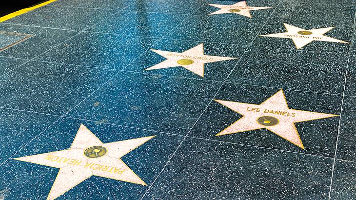 A black-tiled street with rows of inlaid stars with names in gold on it