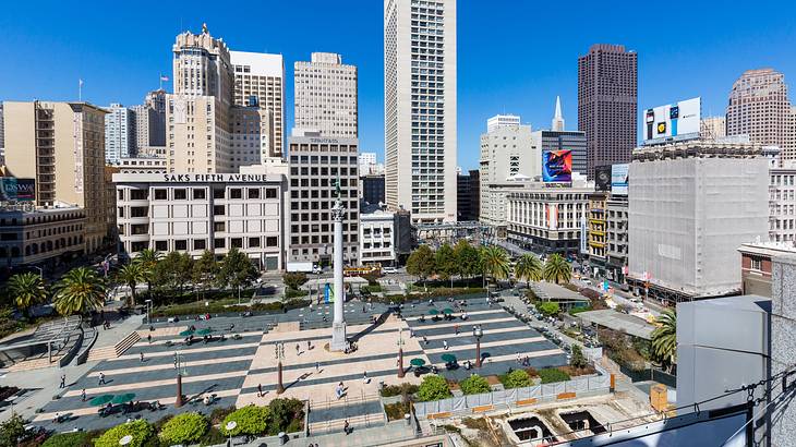 A plaza with a skating rink in the center and a tall monument surrounded by trees