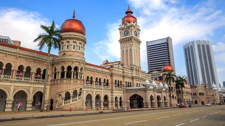 An old historical building's facade with red dome tops against a partly cloudy sky