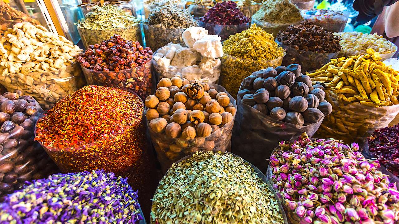 Close-up of rows of colorful spices in cylinder containers displayed on a slant