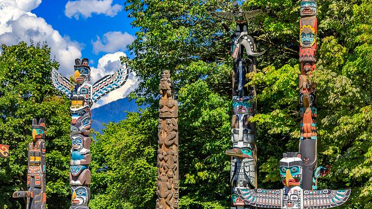 Tall Indigenous totem poles amongst greenery