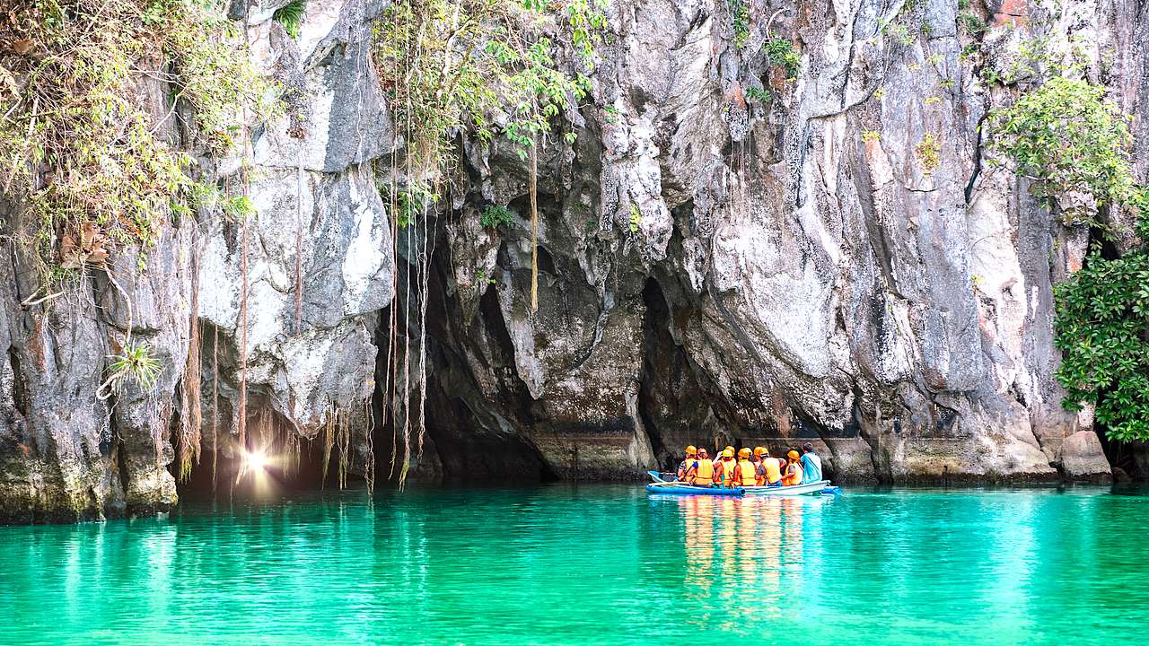 A boat full of people waiting to enter a cave for an underground river