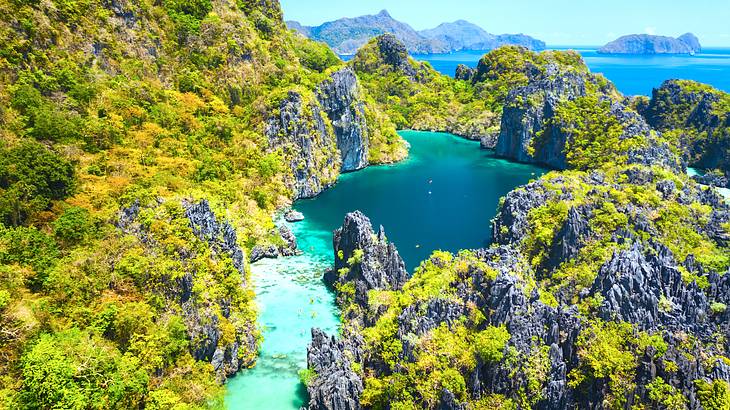 A big lagoon with blue water among rocky cliffs with patches of greenery