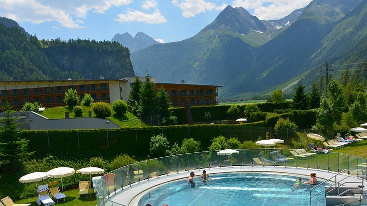 A round thermal pool at a hotel with greenery-covered mountains around it