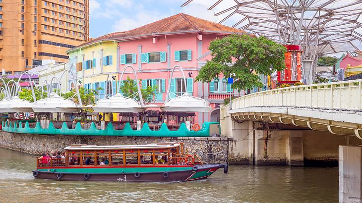 Colourful buildings, a walkway over water and a boat in Clark Quay, Singapore Colourful buildings, a walkway over water and a boat in Clark Quay, Singapore