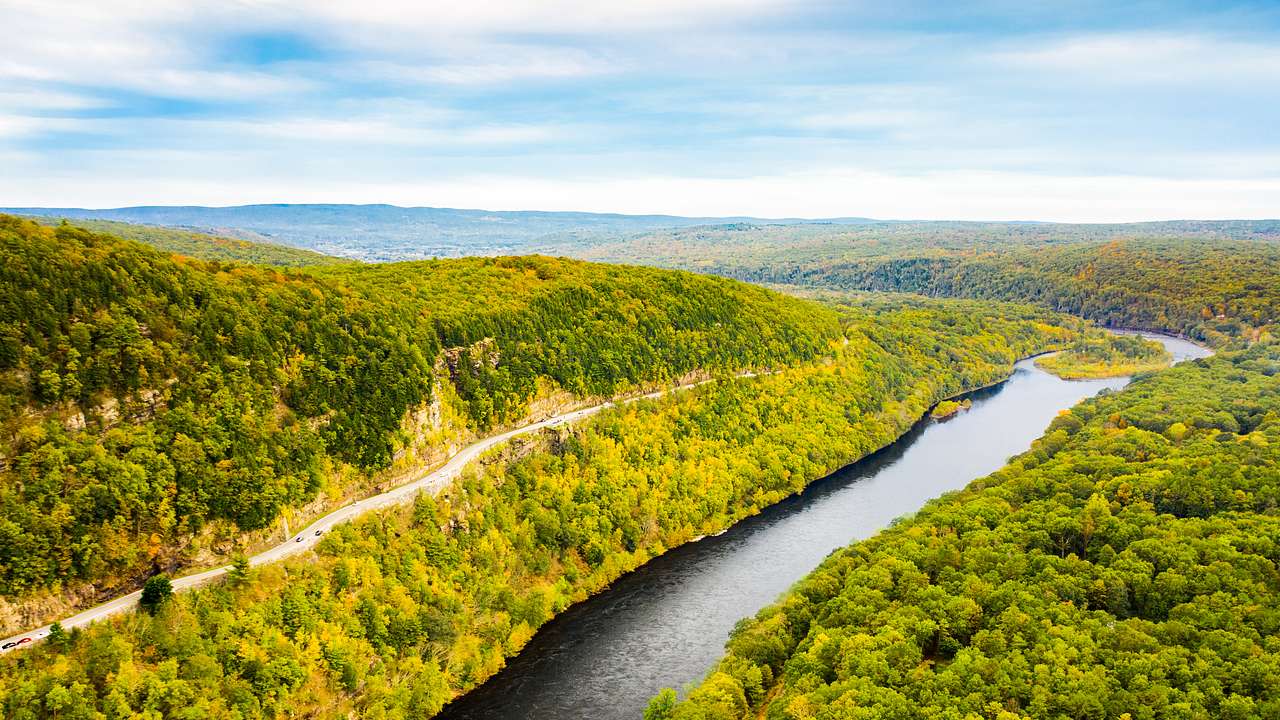 Aerial view of a river with both sides covered in fall foliage
