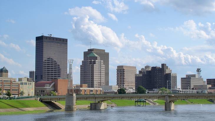 A bridge over a river in the foreground of buildings and skyscrapers