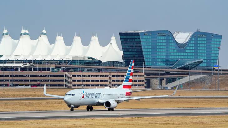An American Airlines flight on a runway in front of the airport terminal