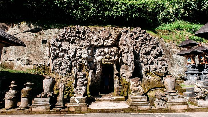 A stone cave-type structure with faces carved into it