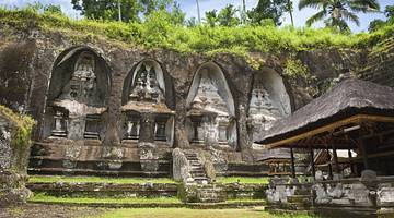 An ancient temple with carvings in rock and greenery