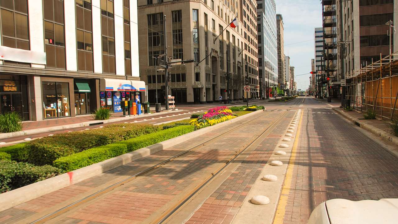 A street with tram tracks and buildings on one side