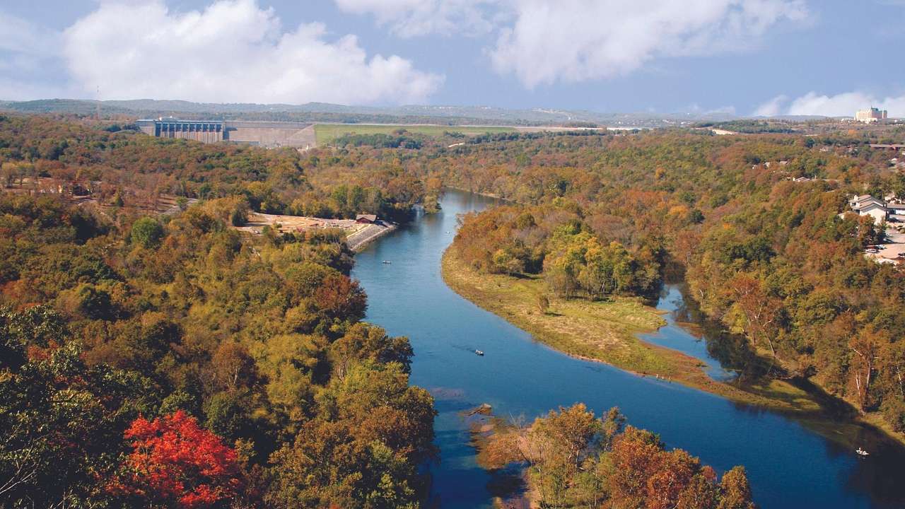 An aerial view of a river surrounded by autumn trees