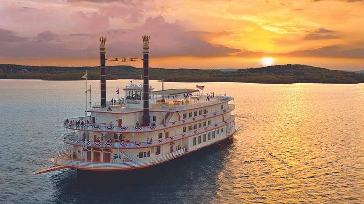 An old-fashioned showboat on the water at sunset
