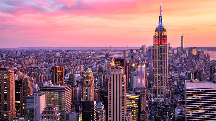The NYC skyline with Empire State Building under a pink sky The NYC skyline with Empire State Building under a pink sky