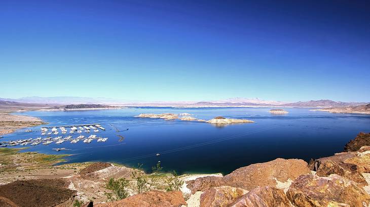A lake with mountains surrounding and small islands in the water A lake with mountains surrounding and small islands in the water