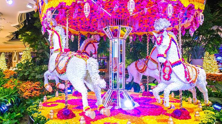 A pink, white, yellow, and orange carousel display made from flowers A pink, white, yellow, and orange carousel display made from flowers