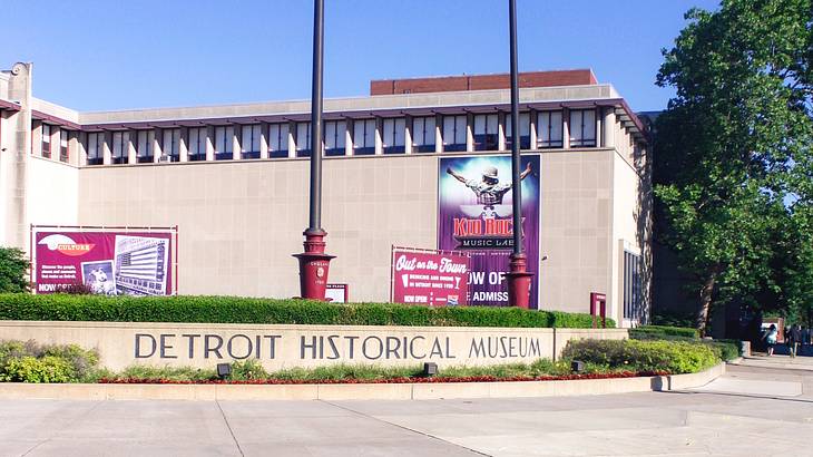 A stone museum with a "Detroit Historical Museum" sign and colorful banners