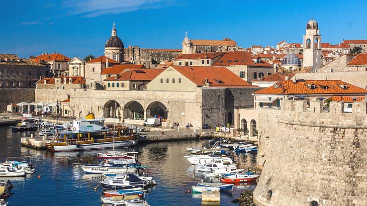 Boats in a harbour next to a city with stone buildings