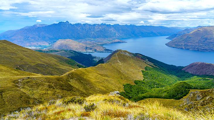 View over water and other grassy mountains from high above