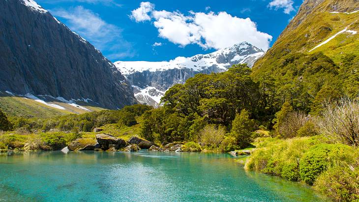 A turquoise lake with snowy mountains at the back