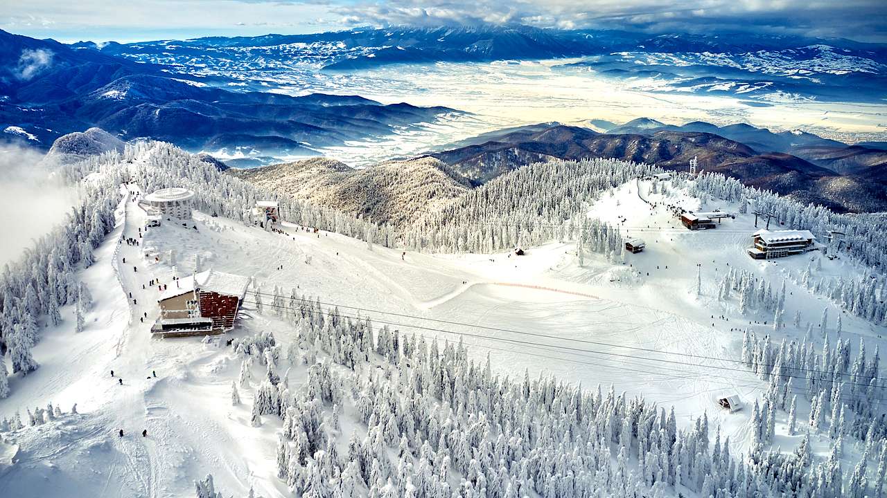A snow-covered mountain top of a ski resort in Brasov, Romania