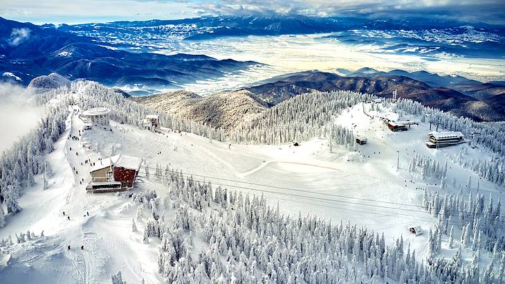 A snow-covered mountain top of a ski resort in Brasov, Romania