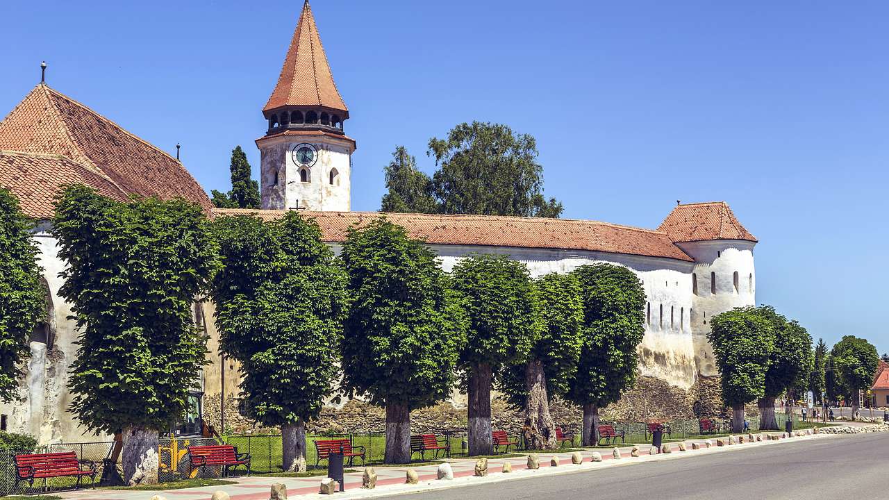 A view of a church, green trees, and clear blue sky, Prejmer, Romania