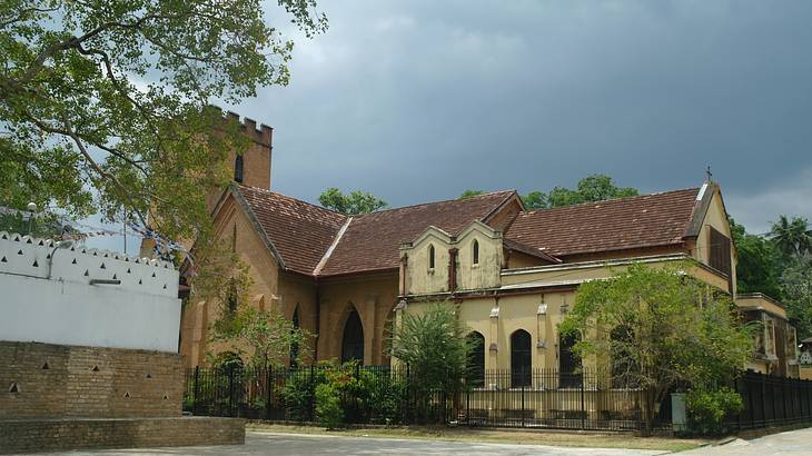 A Neo-Gothic church with terracotta bricked top on a cloudy day
