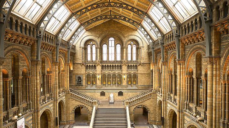 Golden, cathedral-like inside of a museum, view above a grand staircase, London