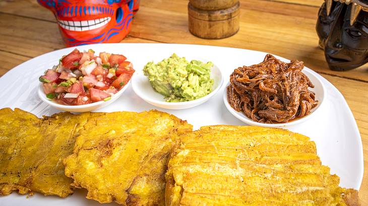 Wooden table with a colorful and healthy local dish served on a plate