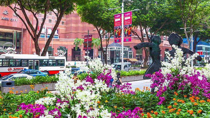 Busy Orchard Road with buses and behind a row of flowers, Singapore