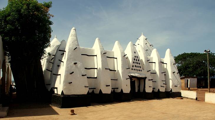 The outside pointy architecture of an old white mosque in Ghana