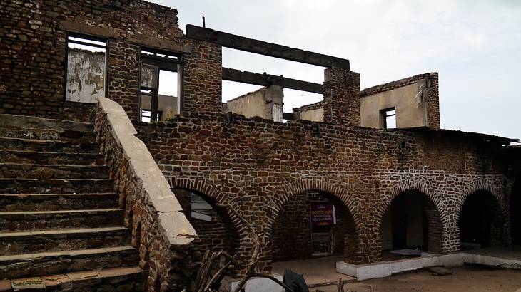 The outside of an old fort with a staircase in Accra, Ghana