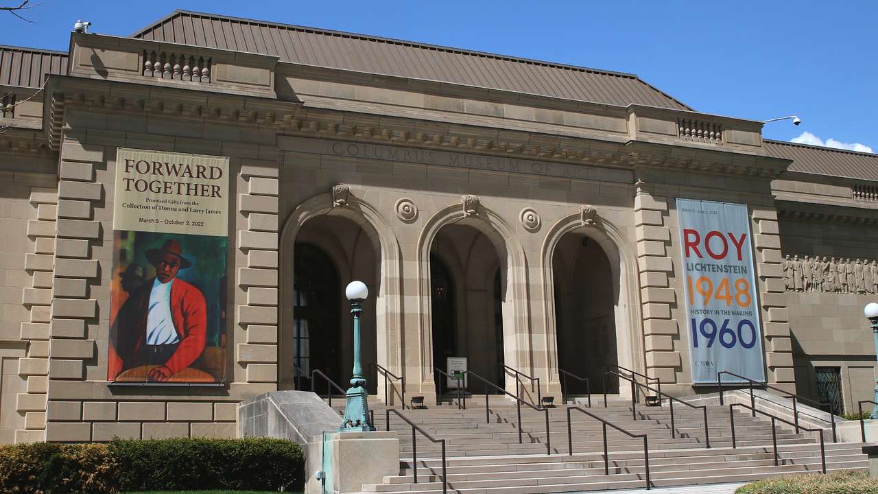 A stone museum with banners and "Columbus Museum of Art" carved on it