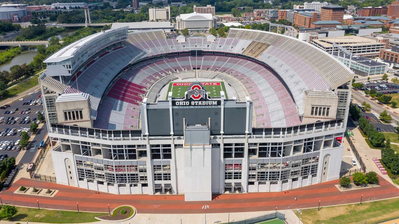 An aerial view of a football stadium with red seats and an "Ohio Stadium" sign