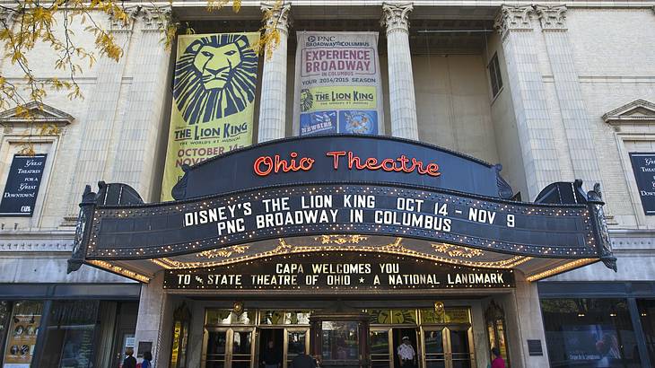 The front of a theater with columns, an "Ohio Theatre" sign, and show banners