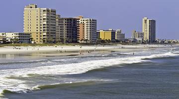 The ocean next to a beach and beachside apartment blocks