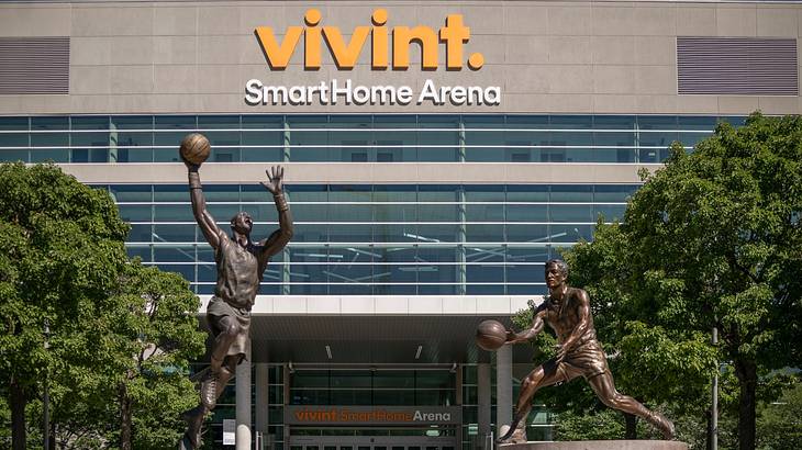 An arena with a "Vivint SmartHome Arena" sign and two basketball statues in front