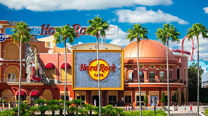 Iconic "Hard Rock Cafe" signage on a dome-shaped building by a garden