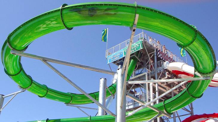 A green water slide under a blue sky