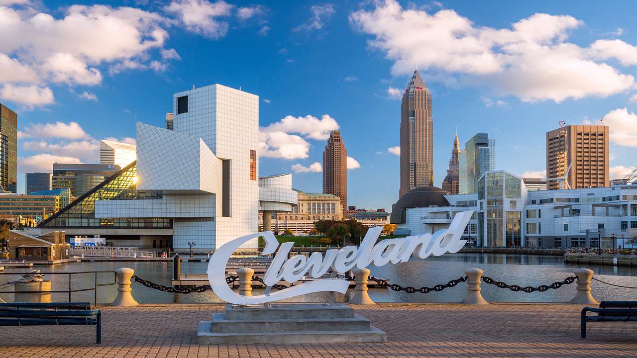 Buildings in the distance with the sign "Cleveland" in front next to a walkway